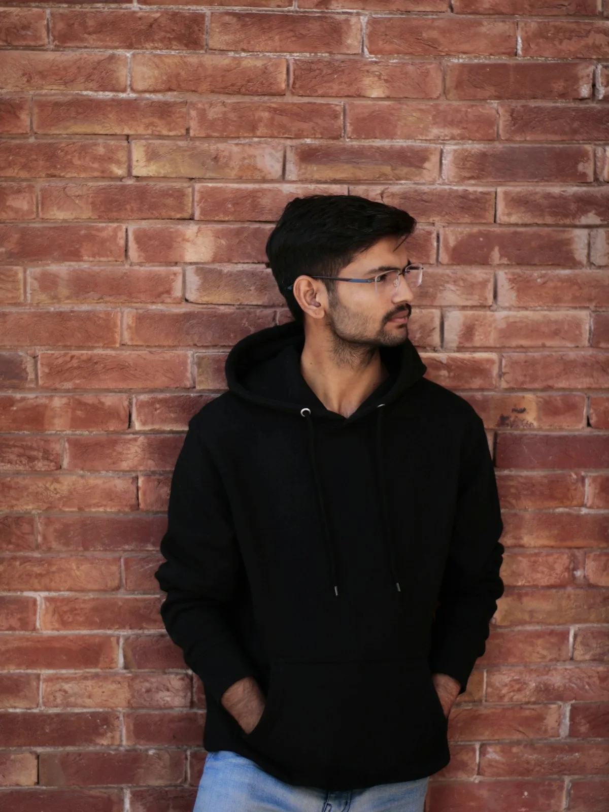 Man turning his face while standing against a wall
